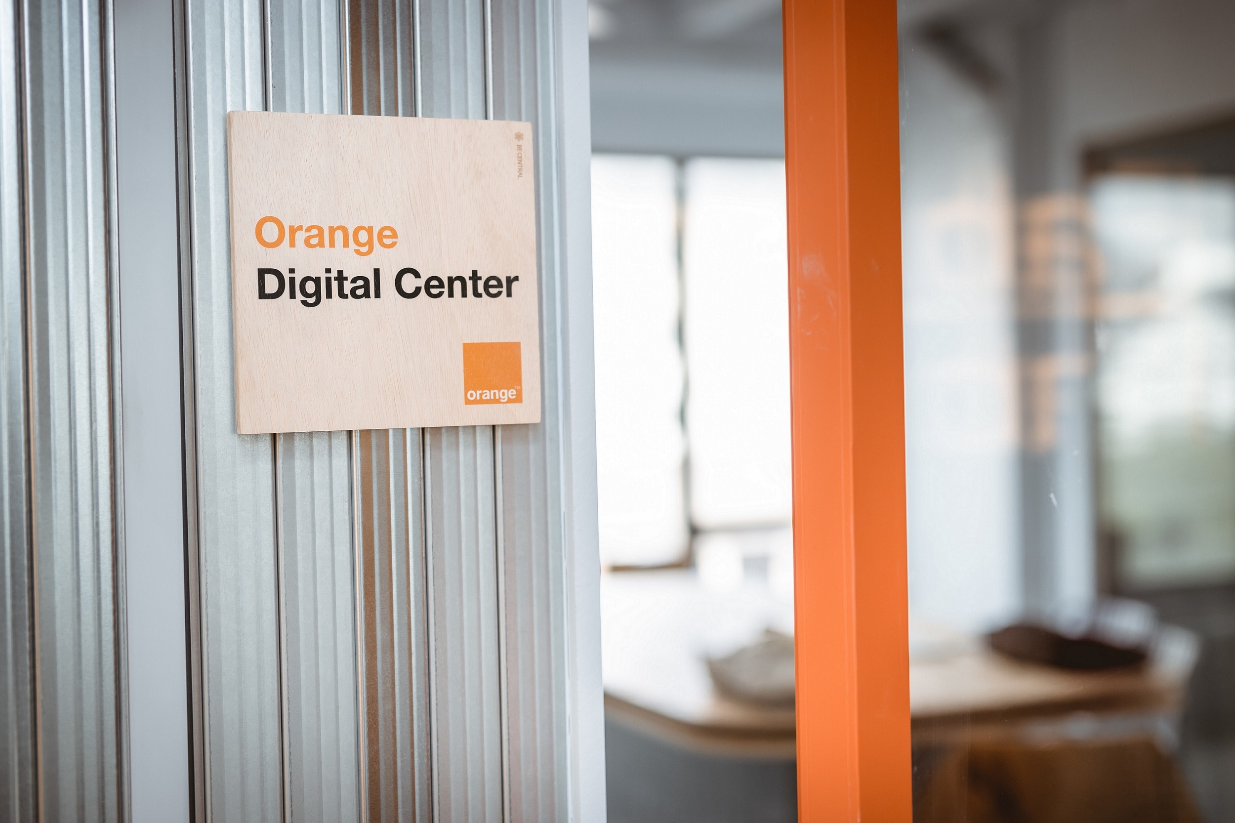 An illustrative picture showing the door of our Orange Digital Center, with a small wooden panel with its name written on it.