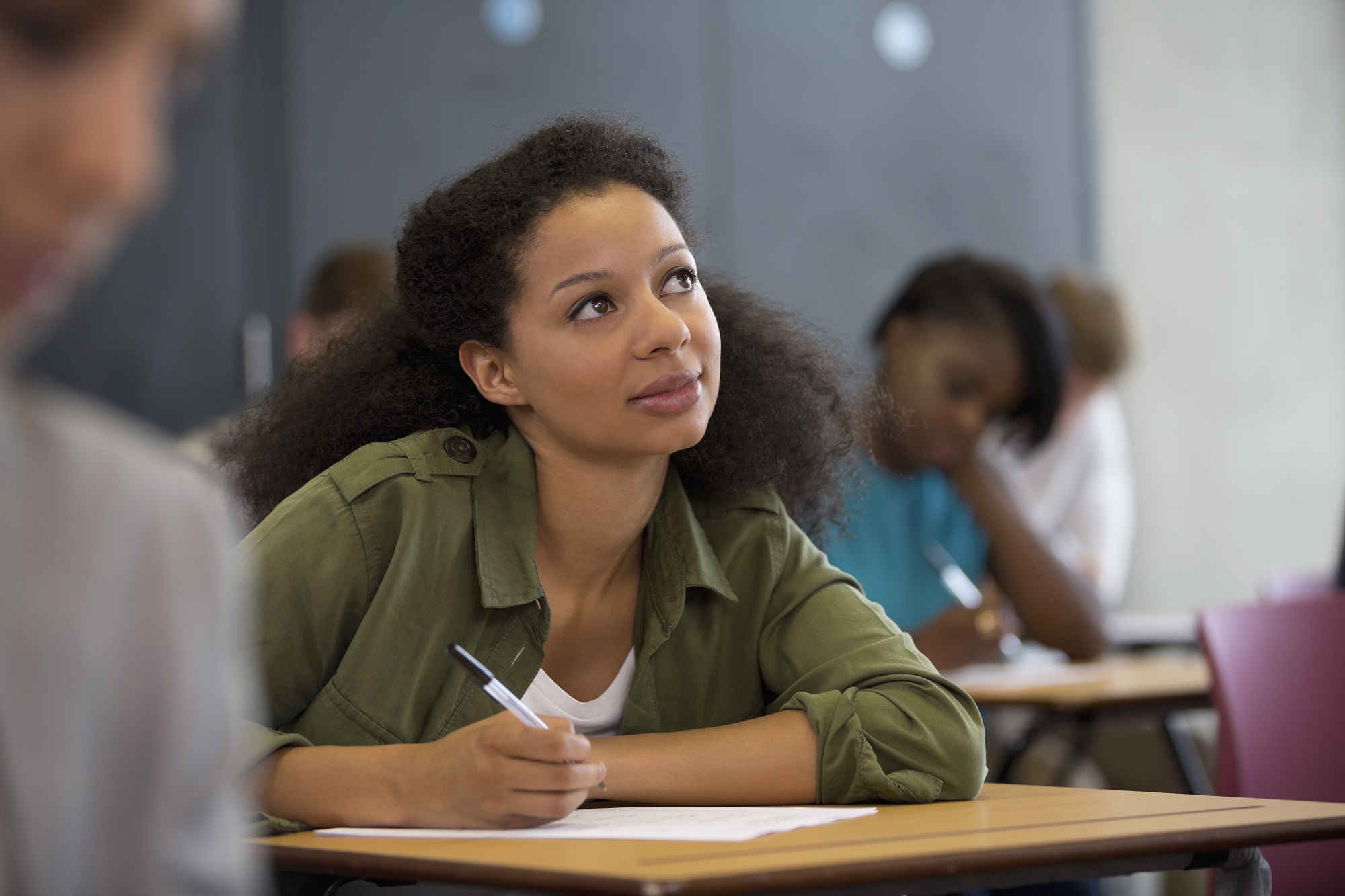 Een illustratieve afbeelding van een vrouw die in een klas vol andere studenten in zichzelf denkt