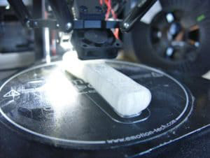 A 3D printer currently printing a white object